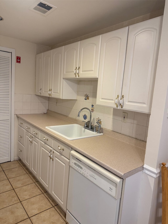 kitchen with light countertops, white dishwasher, a sink, and white cabinetry