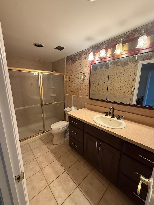 bathroom featuring a wainscoted wall, tile walls, tile patterned floors, a stall shower, and wallpapered walls