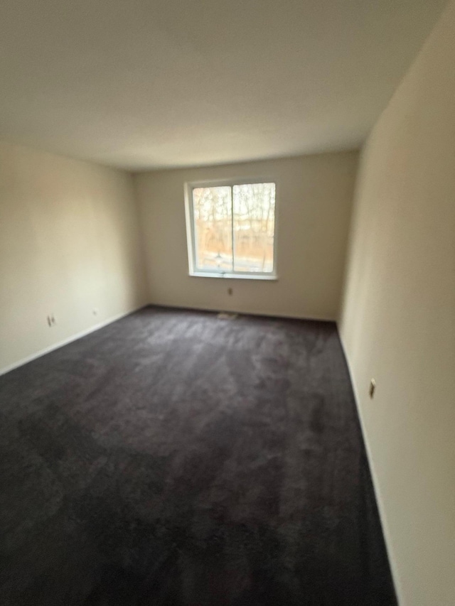 spare room with dark carpet