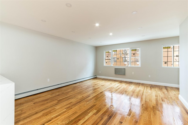 unfurnished room featuring baseboards, recessed lighting, a baseboard radiator, and light wood-style floors