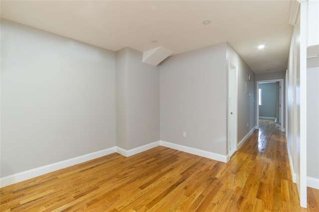 hallway featuring light wood-style flooring, baseboards, and recessed lighting