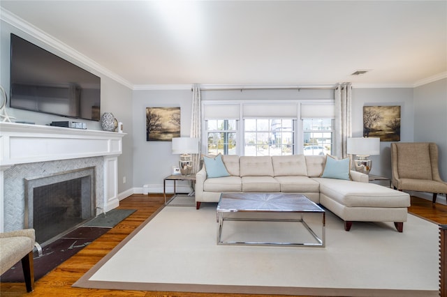 living area with a fireplace with flush hearth, visible vents, wood finished floors, and ornamental molding