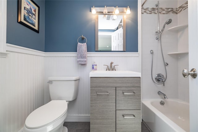 full bathroom with shower / bathing tub combination, wainscoting, vanity, and toilet