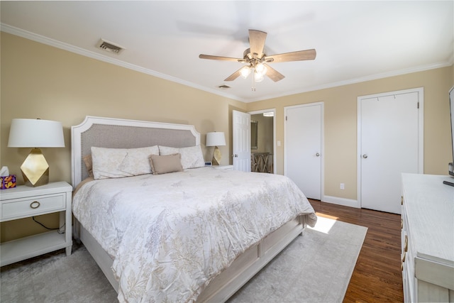 bedroom with crown molding, dark wood finished floors, visible vents, ceiling fan, and baseboards