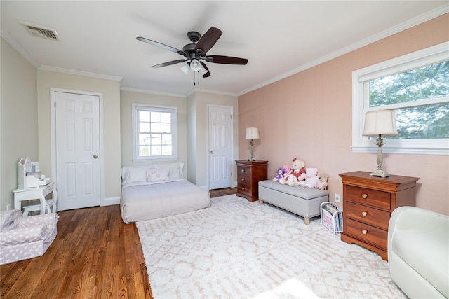 living area featuring ornamental molding, wood finished floors, visible vents, and a ceiling fan