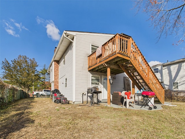 rear view of property with a patio, fence, stairs, a yard, and a wooden deck