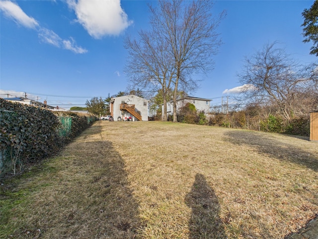 view of yard featuring fence and stairs