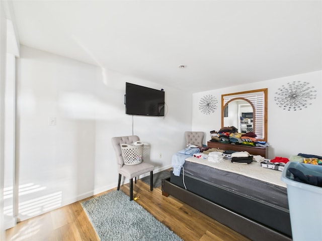 bedroom with baseboards and wood finished floors