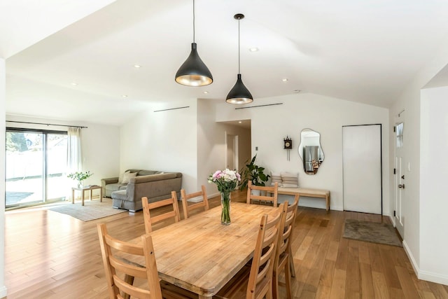 dining space with light wood-type flooring, lofted ceiling, baseboards, and recessed lighting