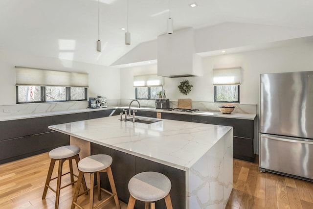 kitchen featuring stainless steel appliances, a breakfast bar area, modern cabinets, and a sink