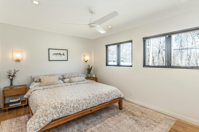 bedroom featuring ceiling fan, baseboards, and wood finished floors