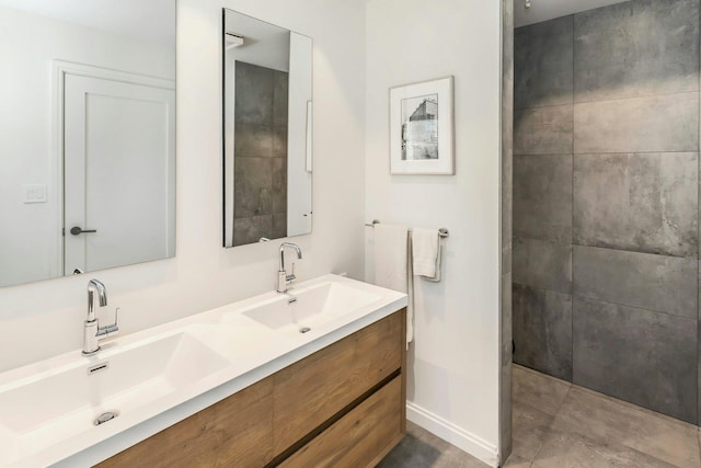 full bathroom with double vanity, a tile shower, and a sink