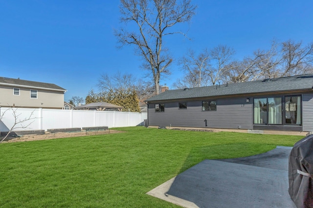 rear view of property featuring a yard, a vegetable garden, a chimney, and fence