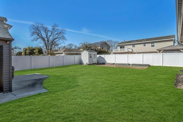 view of yard with a fenced backyard, an outdoor structure, a storage shed, and a patio