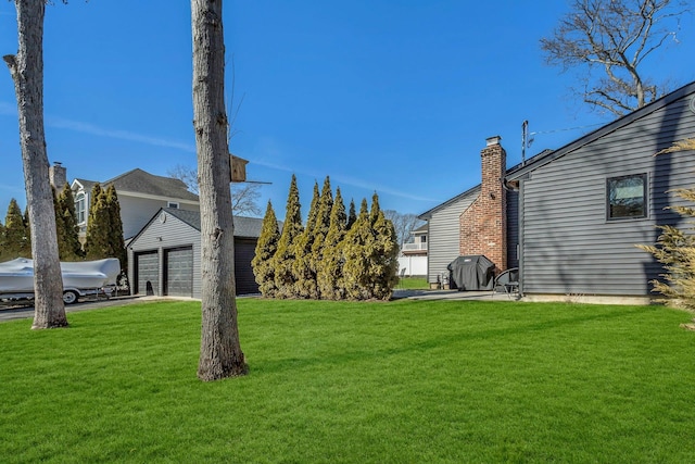 view of yard with a garage and an outbuilding