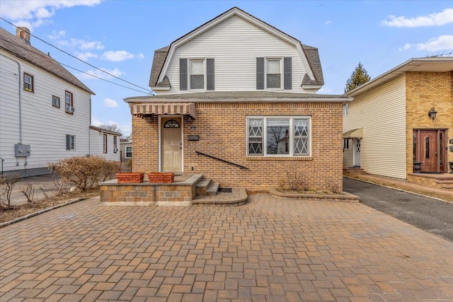 dutch colonial with brick siding and a gambrel roof