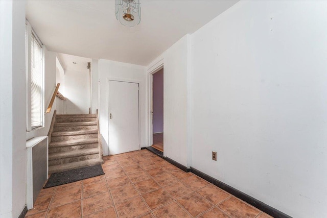 stairway featuring baseboards and tile patterned floors