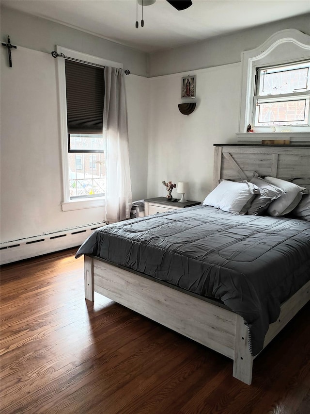 bedroom featuring a baseboard radiator, a ceiling fan, and wood finished floors