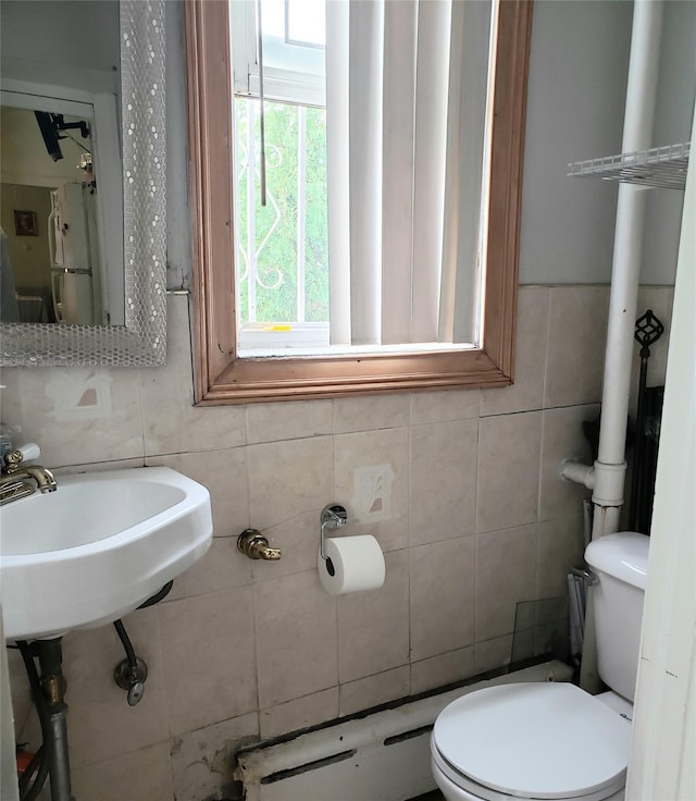 bathroom featuring toilet and tile walls