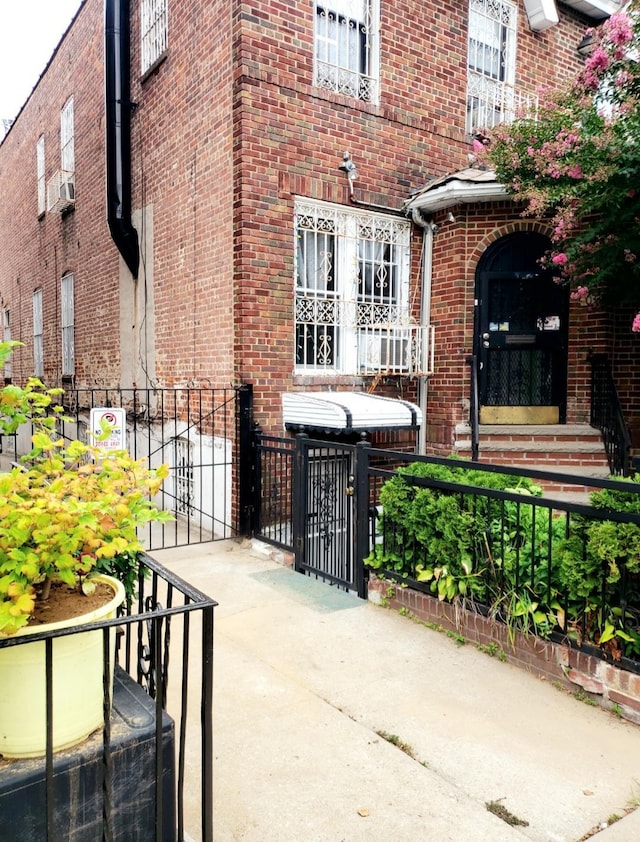 exterior space featuring brick siding, fence, and a gate