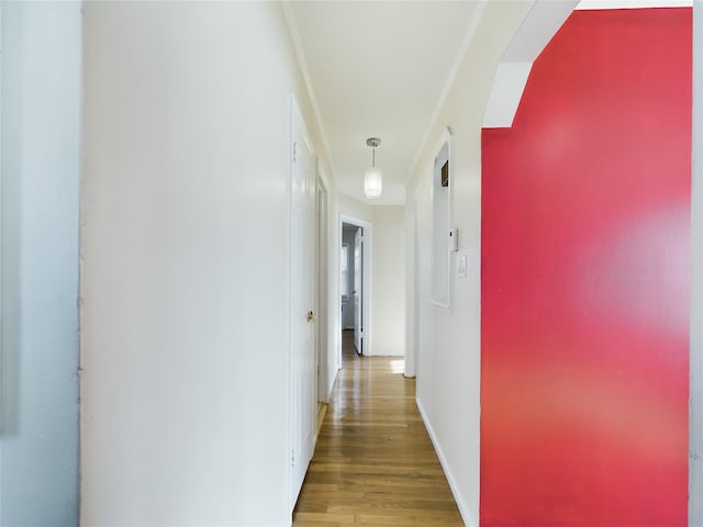 corridor featuring wood finished floors and baseboards