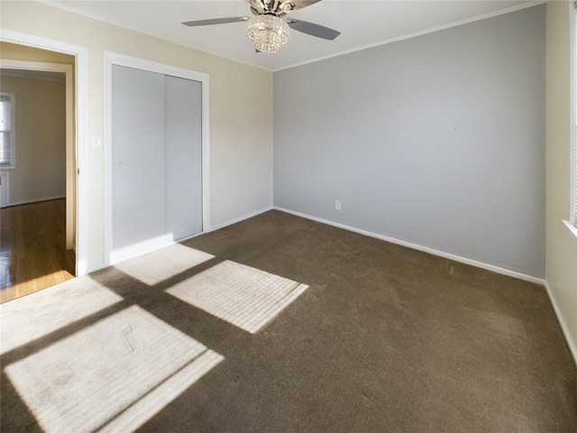 unfurnished bedroom featuring carpet, crown molding, a closet, ceiling fan, and baseboards