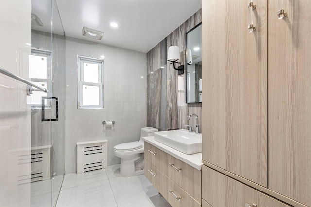 full bath featuring tile walls, toilet, a stall shower, vanity, and tile patterned floors