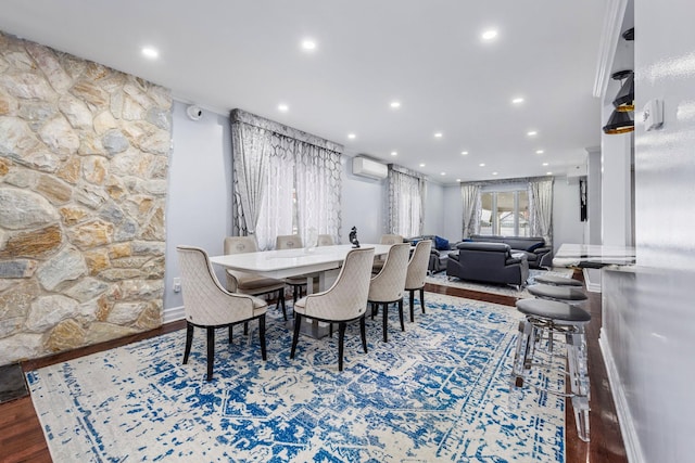 dining space with dark wood-type flooring, an AC wall unit, and recessed lighting