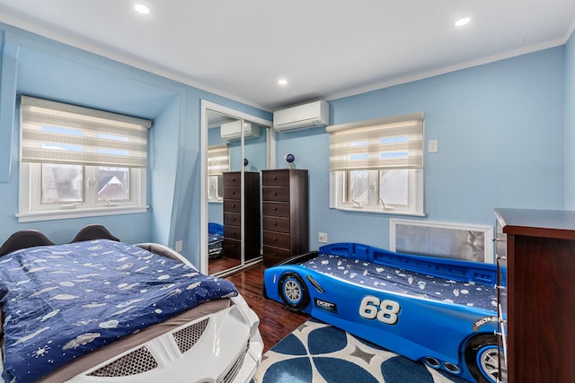 bedroom featuring dark wood-style floors, a closet, a wall mounted AC, ornamental molding, and an AC wall unit