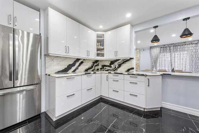 kitchen featuring modern cabinets, glass insert cabinets, white cabinets, and freestanding refrigerator