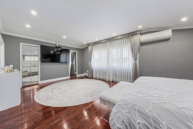 bedroom with ornamental molding, a wall unit AC, and wood finished floors