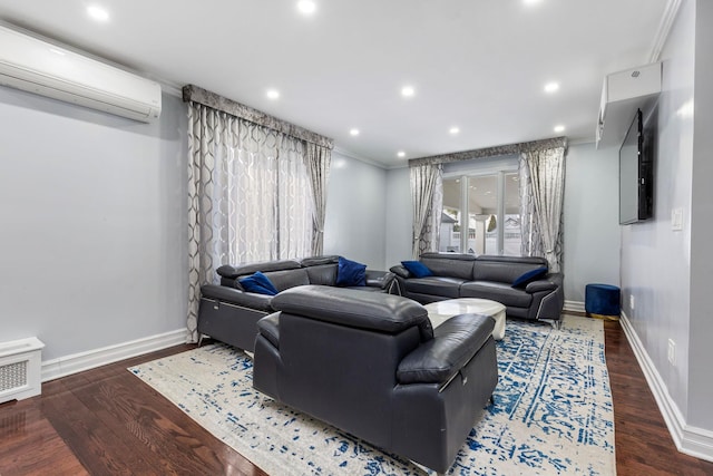 living area with ornamental molding, a wall unit AC, dark wood finished floors, and baseboards