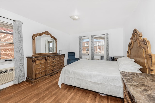 bedroom featuring a wall mounted air conditioner and wood finished floors