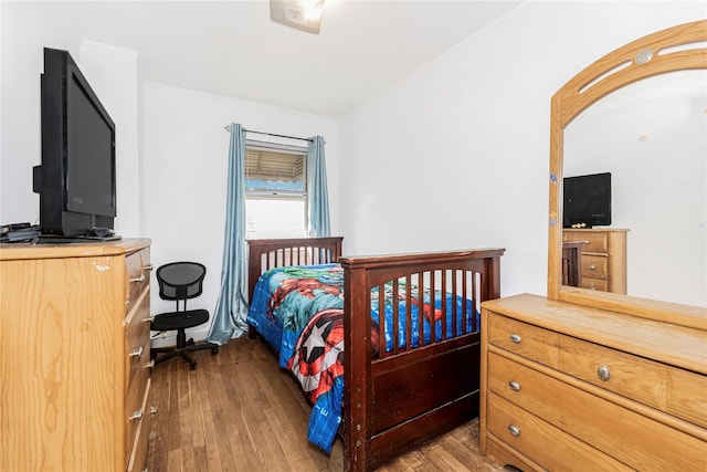 bedroom featuring arched walkways, hardwood / wood-style floors, and crown molding