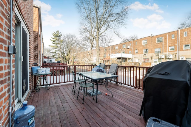 wooden deck with grilling area and outdoor dining space