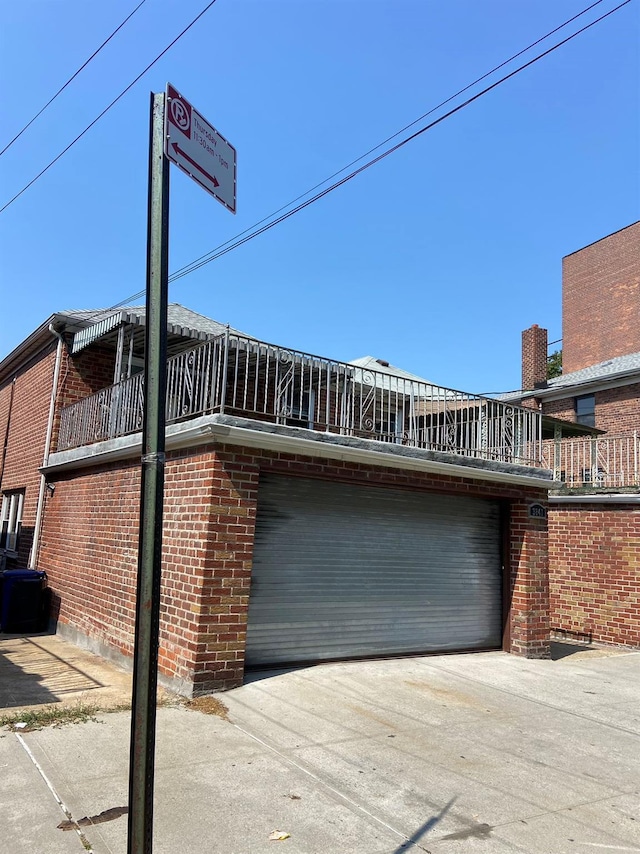 view of side of home featuring concrete driveway and brick siding