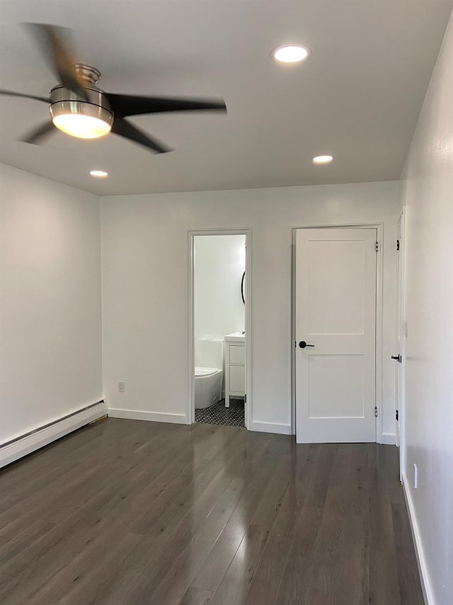 unfurnished bedroom featuring baseboards, dark wood finished floors, connected bathroom, baseboard heating, and recessed lighting