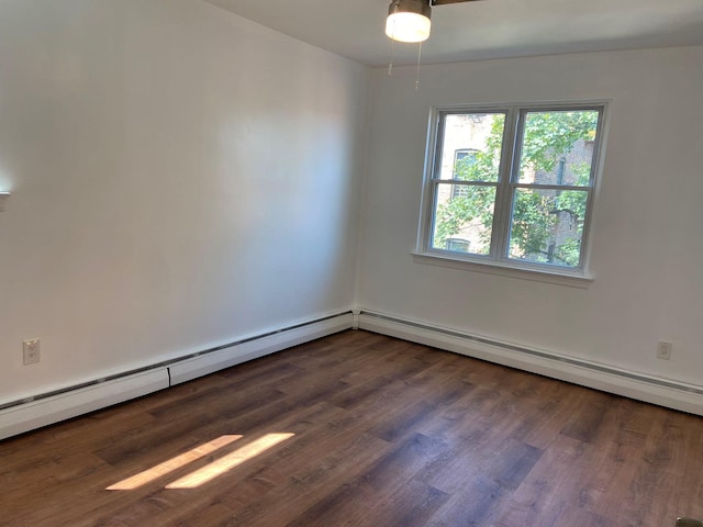 unfurnished room with dark wood-type flooring and a baseboard radiator