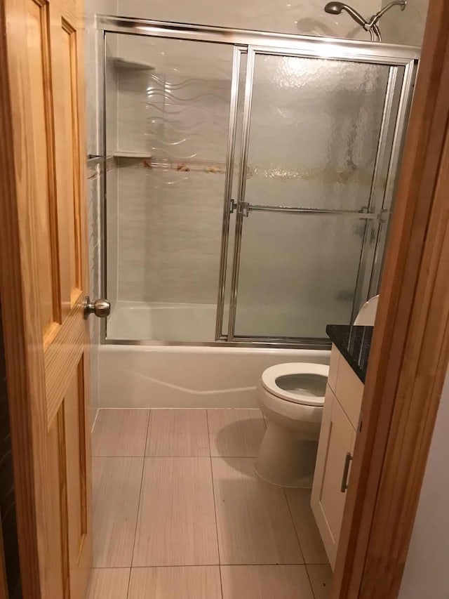 full bath with toilet, tile patterned flooring, enclosed tub / shower combo, and vanity