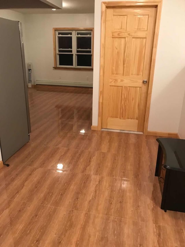 corridor with wood finished floors and baseboards