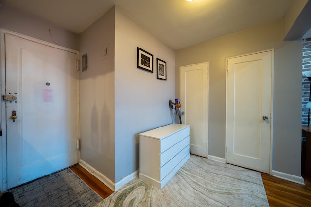entryway featuring baseboards and wood finished floors