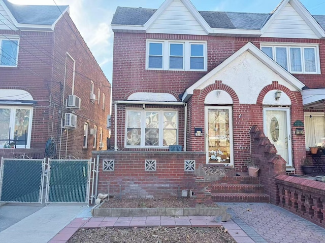 view of front of house with a shingled roof, a gate, and brick siding