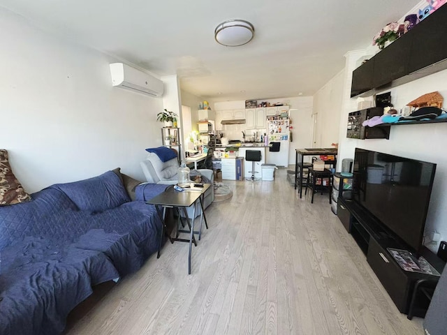 living room featuring light wood-type flooring and an AC wall unit