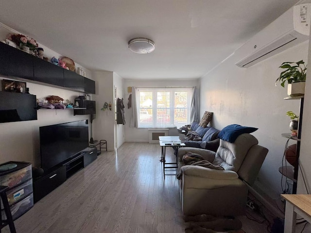 living room featuring an AC wall unit and wood finished floors