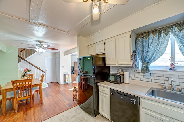 kitchen with ceiling fan, light wood-style flooring, a sink, light countertops, and black appliances