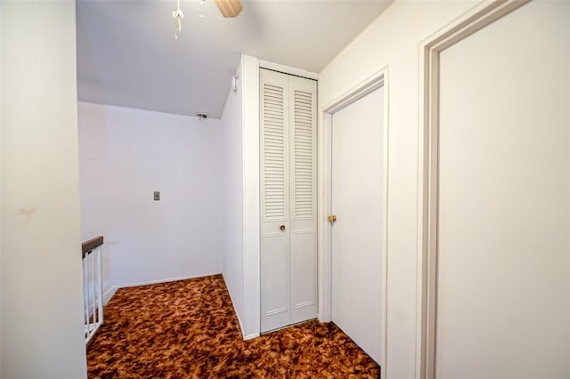 hall featuring carpet flooring and an upstairs landing