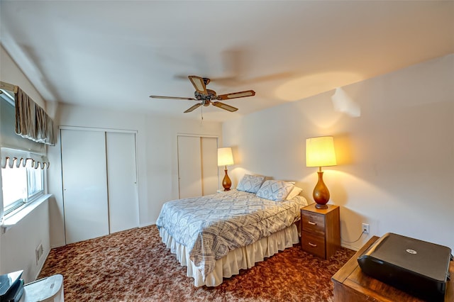 bedroom featuring carpet floors, a ceiling fan, and two closets