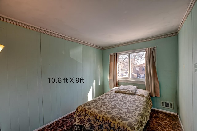 carpeted bedroom featuring baseboards, visible vents, and crown molding