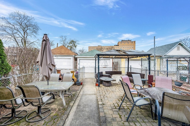 view of patio / terrace featuring a gazebo, outdoor dining area, fence, and an outbuilding