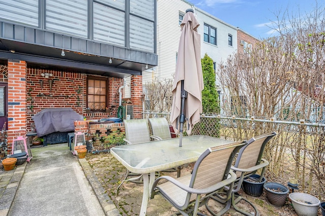 view of patio / terrace featuring a grill, outdoor dining space, and fence